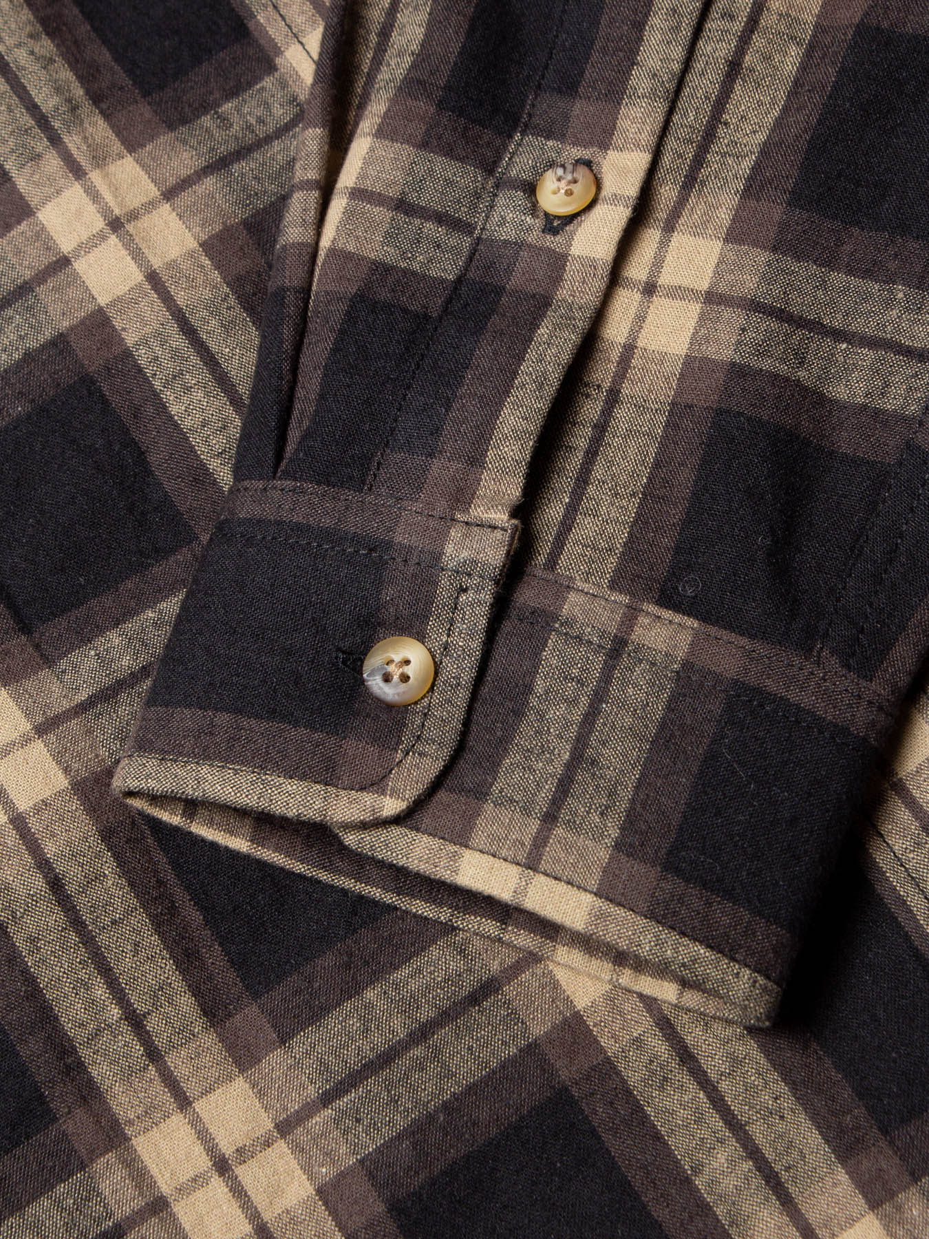 A flannel shirt material with a dark brown plaid check.