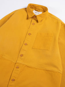 A close-up of the KESTIN Rosyth Overshirt in Ochre Yellow.