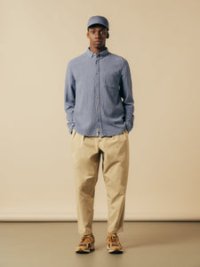 A model wearing a blue long sleeve shirt and tan pants from KESTIN.