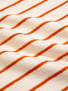 A textured, woven organic cotton fabric with a white and orange striped pattern.