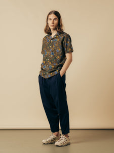 A model wearing a green floral shirt and navy trousers from Scottish designer KESTIN.