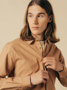 A model buttoning up the Dirleton Shirt from menswear designer KESTIN.