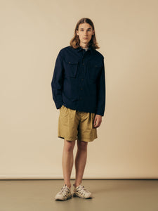 A model wearing a fatigue jacket and a pair of shorts from KESTIN.