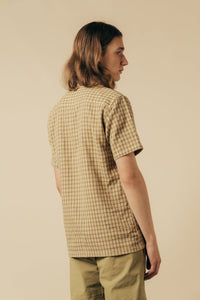 A man wearing a short sleeve shirt with a casual check pattern.
