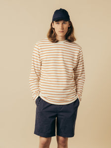 A model wearing a long sleeve stripe tee and a pair of shorts.
