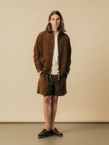 A model wearing matching shirt and shorts, in a rust brown paisley corduroy.
