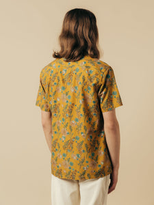 A men's short sleeve shirt in a yellow floral graphic print, worn on a model.