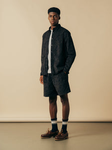 A model wearing a matching shirt and shorts in a navy blue paisley pattern.