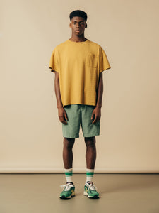 A model wearing the relaxed fit Fly Tee from KESTIN, in Ochre Yellow.