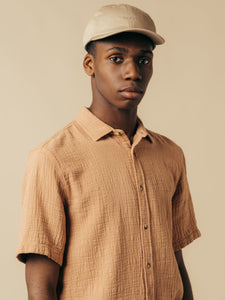 A model wearing a textured short sleeve shirt and cap from menswear designer KESTIN.