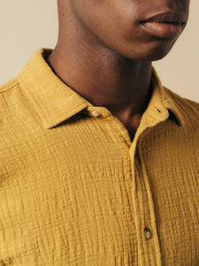 The collar of a men's short sleeve shirt in a textured yellow cotton.