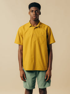 A model wearing a short sleeve shirt in ochre yellow.