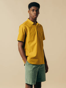 A man wearing a short sleeve shirt and shorts from menswear brand KESTIN.