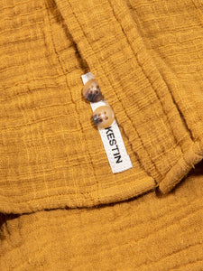 A textured cotton material, garment dyed in yellow.
