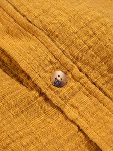 A button sewn to the KESTIN Aberlady Shirt in textured yellow cotton.