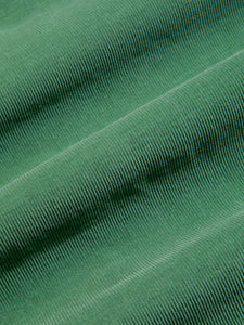 An organic cotton corduroy material, garment-dyed in fern green.