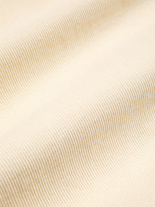 An ecru white corduroy material, made from 100% organic cotton.