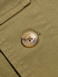 A branded button on a ripstop fabric, from menswear brand KESTIN.