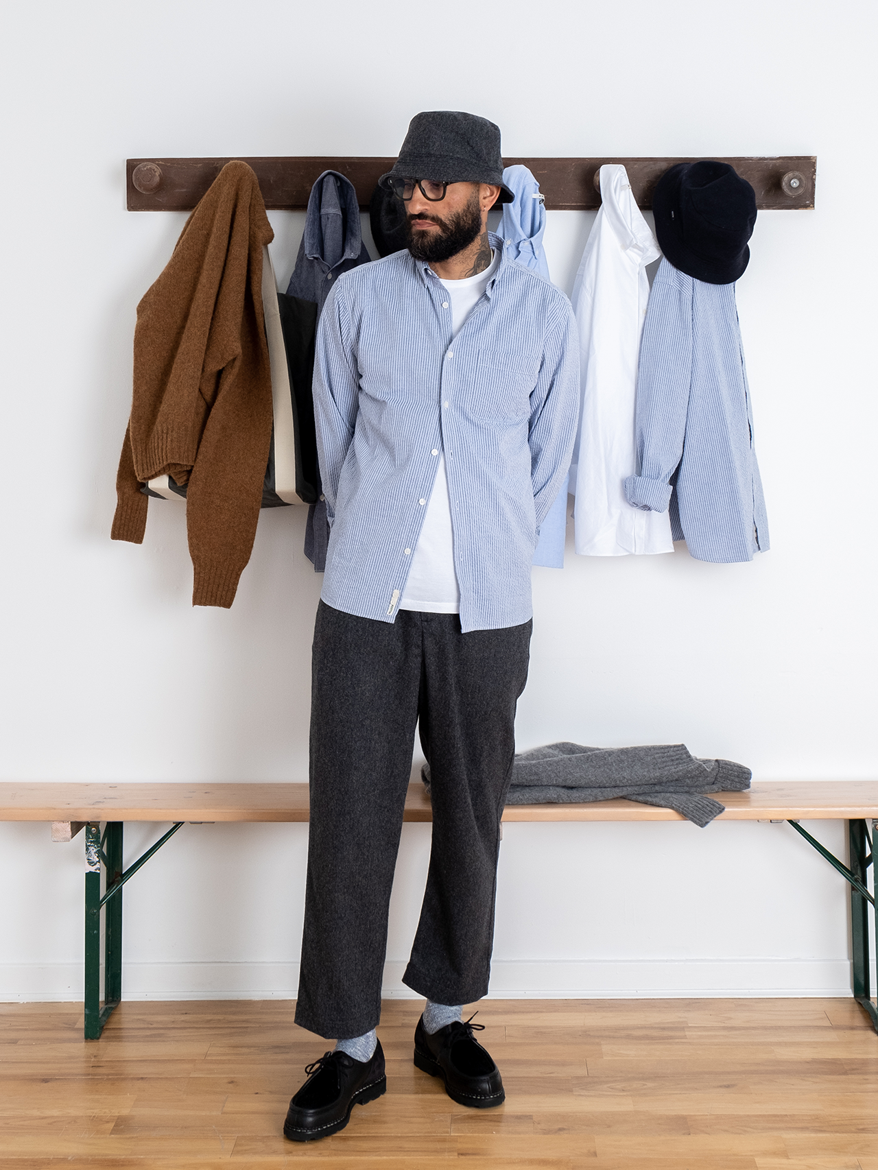 This model is wearing the Raeburn Button Down, a classic men's Oxford Shirt silhouette, in a blue striped Seersucker fabric.